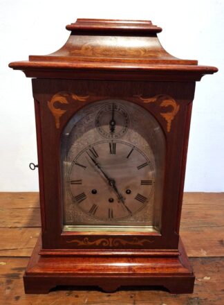 LOT 314 () Est R2000 to R4000 - An Early 20th Century German Mahogany and Fruitwood Inlaid Gustav Becker Bracket Mantel Clock in the Classical taste